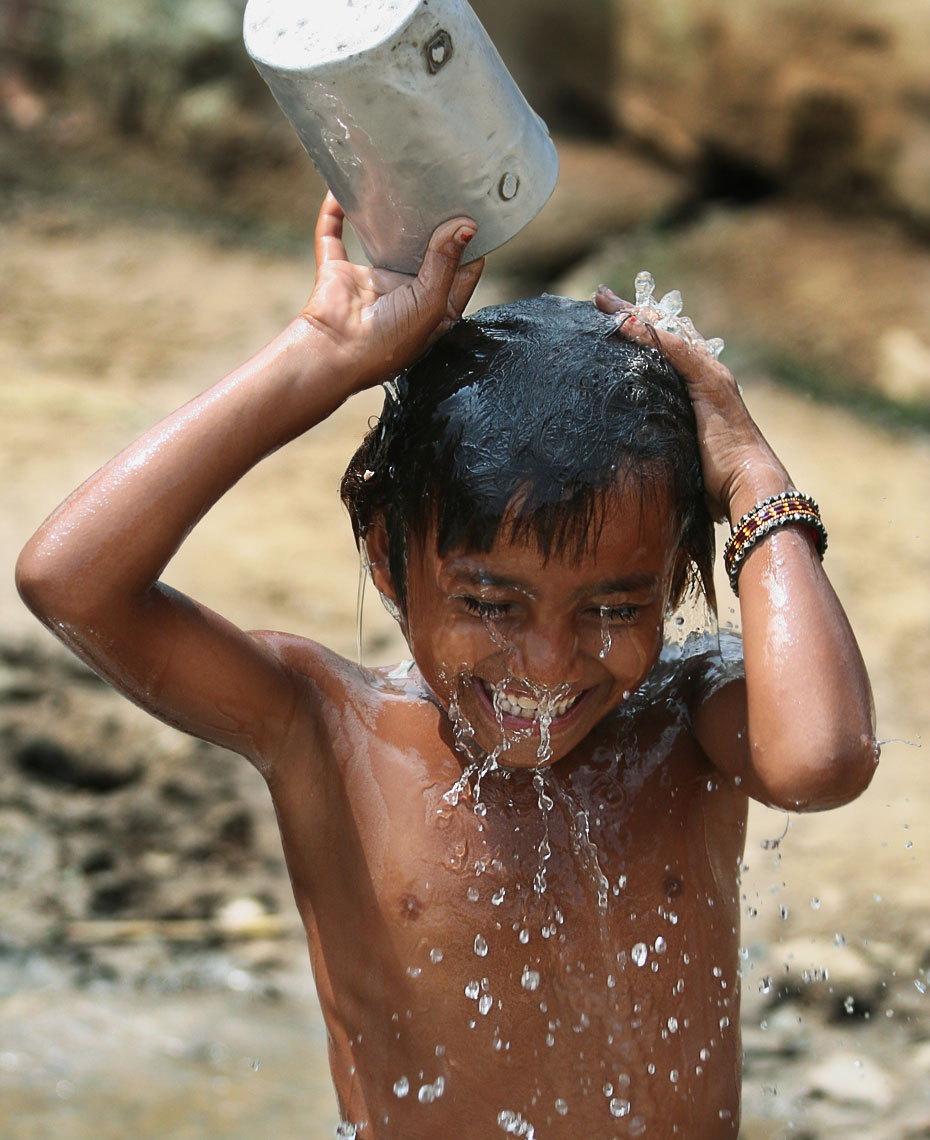 indian-boy-dumping-pale-of-water.jpg